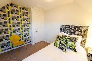 a bedroom with a bed and a yellow chair at The Old Vine in Winchester