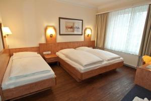 Säng eller sängar i ett rum på Hotel Wikinger Hof