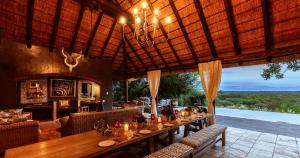 a dining room with a long table in a restaurant at Khaya Ndlovu Safari Manor in Hoedspruit