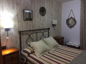 a bedroom with a bed and two lamps and a mirror at Duplex Torico Amantes in Teruel