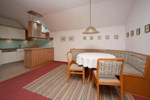 a kitchen and dining room with a table and chairs at Pension Seevilla Annelies in Maria Wörth