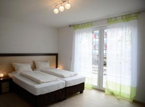 a bedroom with a bed and a large window at Naturparkhotel & Landgasthof Stromberg in Sachsenheim