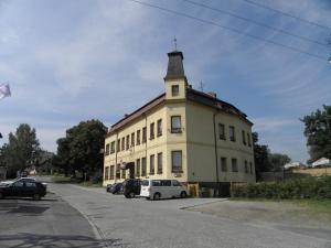 ein gelbes Gebäude mit einem Turm darüber in der Unterkunft Hotel U Branky in Stříbro