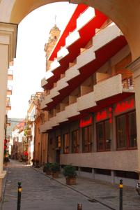 un bâtiment avec une arche à côté d'une rue dans l'établissement Hotel Colibrì, à Finale Ligure