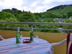 een tafel met twee wijnflessen en glazen op een balkon bij Ferienwohnung in der Nähe des Skigebietes in Willingen