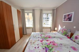 une chambre avec un grand lit avec un couvre-lit fleuri dans l'établissement Ferienhaus Burgblick Brueggen, à Brüggen