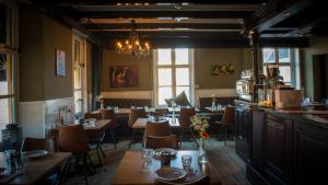 ein Restaurant mit Tischen, Stühlen und einem Kronleuchter in der Unterkunft Hanze Hotel Zwolle in Zwolle