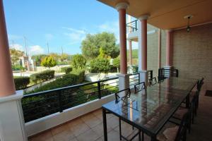 een balkon met een glazen tafel en stoelen erop bij Niso Villas in Yírion