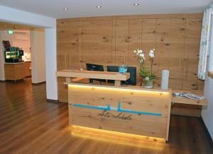a store with a wooden wall with a table and flowers at Hotel Alte Schule in Lindau
