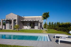 uma villa com piscina em frente a uma casa em Villa Lefteris em Svoronata