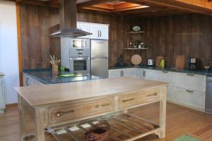 a kitchen with a wooden island in the middle at Noz Por Cá... Turismo Em Espaco Rural in Alcaria