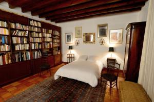 a bedroom with a white bed and bookshelves at L'Atelier du Grison in Callen