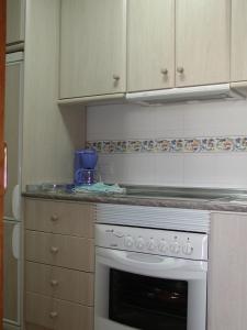 a kitchen with a white stove top oven at Urbanización Naturista Bahía de Vera in Vera