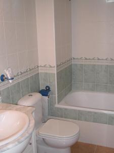 a bathroom with a toilet and a tub and a sink at Urbanización Naturista Bahía de Vera in Vera