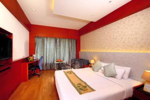 una camera d'albergo con letto e TV di Diana Heights Luxury Hotel a Nedumbassery
