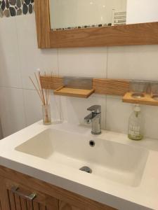 a white sink in a bathroom with a mirror at Studio Bourdonnais in Paris