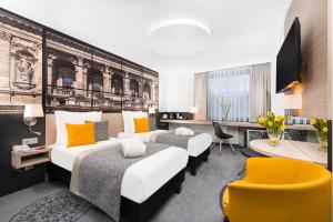 a hotel room with two beds and a tv at Mercure Budapest City Center in Budapest