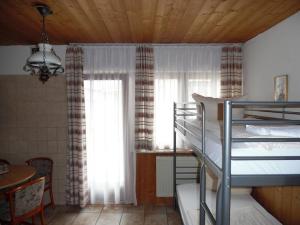 a bedroom with two bunk beds and a table and a window at Hotel Edelweiß in Oberau