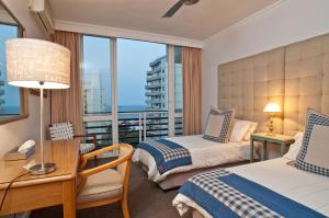 um quarto de hotel com duas camas e uma varanda em 506 Lighthouse Mall - by Stay in Umhlanga em Durban