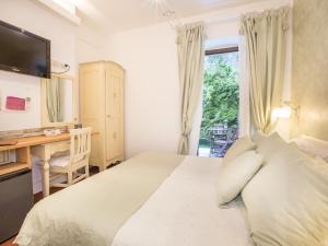 a bedroom with a bed with a desk and a window at Hotel Marina in Monterosso al Mare