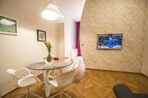 プラハにあるBourgeois Apartment in Cultural Heritage Building by Ruterraのリビングルーム(テーブル、壁掛けテレビ付)