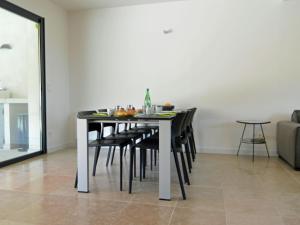 a dining room table with black chairs in a room at Modern villa with private pool in Malauc n in Malaucène