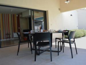 a dining room with a table and black chairs at Modern villa with private pool in Malauc n in Malaucène