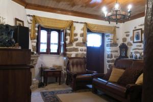 a living room with a couch and chairs and a chandelier at Noz Por Cá... Turismo Em Espaco Rural in Alcaria