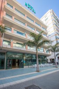 a building with palm trees in front of it at Hotel Torremar - Mares in Torre del Mar