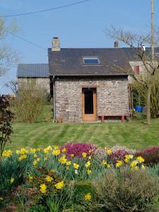 une ancienne maison en pierre avec un jardin fleuri dans l'établissement Le Pti' chez vous, à Saint-Omer