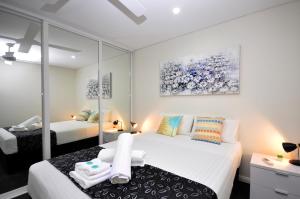 a bedroom with two beds and a mirror at Coastal By Rockingham Apartments in Rockingham