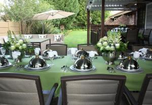 een tafel met theepotten op een groene tafelkleed bij Krith Guest House in Bethlehem