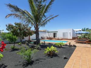 una casa con una piscina y una palmera en Belvilla by OYO Mango 4 pax, en Playa Blanca