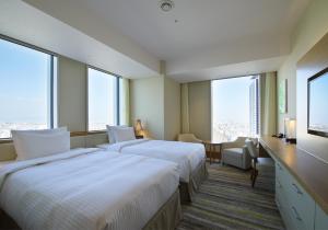 A bed or beds in a room at Nagoya JR Gate Tower Hotel