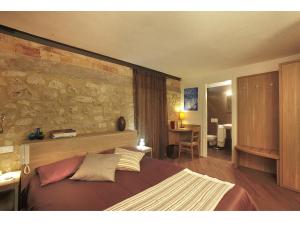 a bedroom with a large bed with a stone wall at Residenze Portacastello in Isernia