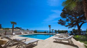una piscina con sedie a sdraio accanto al resort di Hotel Kvarner - Liburnia a Opatija