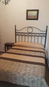 1 cama en un dormitorio con una foto en la pared en Hostal Trajano, en Sevilla