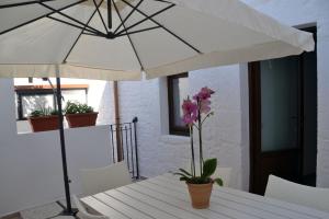 einen Tisch mit einem weißen Regenschirm auf dem Balkon in der Unterkunft Terrazza Sui Trulli in Alberobello
