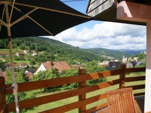 a view from the balcony of a house with an umbrella at Comfortable Holiday Home with Fenced Garden in Natzwiller in Natzwiller
