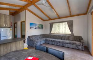 a living room with a couch and a table at Twin Dolphins Holiday Park in Tuncurry