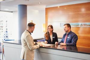 eine Gruppe von drei Personen, die an einer Theke sitzen in der Unterkunft Barcelona Century Hotel in Barcelona