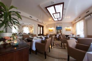 a restaurant with tables and chairs and a chandelier at Naftusya Hotel in Truskavets