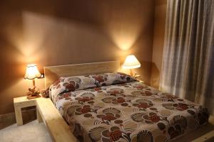チステルナ・ディ・ラティーナにあるCasa Mattia - B&B in Legno & Pagliaのベッドルーム1室(ベッド1台、テーブルにランプ2つ付)