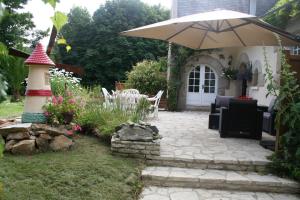 a patio with a lighthouse and an umbrella at Chez Renée et Raynal B&B in Plounévez-Lochrist +47 photos
