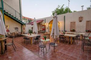 an outdoor patio with tables and chairs and umbrellas at Zimer Baronita in Zikhron Ya‘aqov