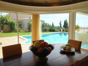 a dining room table with a bowl of fruit on it at Lavish Villa with Private Swimming Pool in Sesmarias