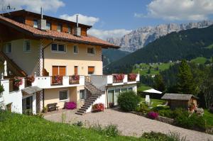 a large building with stairs and flowers on it at Apartments Etruska Gabriela in Santa Cristina Gherdëina