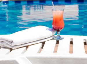 a drink sitting on a table next to a swimming pool at Mika Lodge in Lusaka