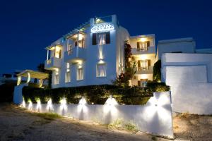 un bâtiment blanc avec un panneau sur lui la nuit dans l'établissement Ostria Hotel , à Adamas