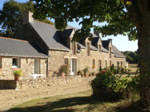 a large stone house with a stone wall at Spacious Holiday Home in Ass rac with a Fenced Pond in Assérac